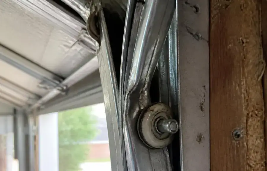 Bent garage door track from a worn, neglected roller